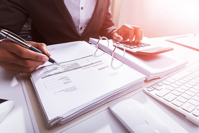 Close-up Of A Businessperson Calculating Bill